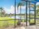 Scenic view of the lake from the screened lanai, surrounded by lush greenery at 4949 Sandy Glen Way, Wimauma, FL 33598