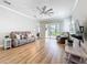 Comfortable living room with wood flooring, a ceiling fan, and sliding glass doors leading to the outdoor area at 4949 Sandy Glen Way, Wimauma, FL 33598