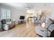 Inviting living room featuring wood flooring, modern lighting, and an open layout connecting to the kitchen at 4949 Sandy Glen Way, Wimauma, FL 33598