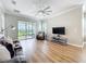 Bright living room features wood floors, neutral paint, and sliding glass doors to the patio at 4949 Sandy Glen Way, Wimauma, FL 33598