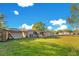 Rear exterior view of home featuring a well-maintained lawn, storage shed and covered porch at 6342 Saddletree Dr, Wesley Chapel, FL 33544