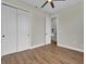 Bright bedroom features wood-look tile flooring, a ceiling fan, and a double door closet at 13575 Abutilon Ln, Port Charlotte, FL 33981