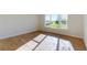 A sunlit bedroom featuring wood-look flooring and a large window with scenic views at 5013 Sea Branch Ave, Apollo Beach, FL 33572