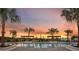The community pool with clear water reflects the stunning sunset between the palm trees at 5013 Sea Branch Ave, Apollo Beach, FL 33572