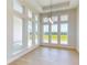 Bright dining room with large windows, wood-look flooring, and elegant pendant lighting at 5013 Sea Branch Ave, Apollo Beach, FL 33572