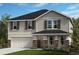 Charming two-story home with a manicured lawn, covered entrance, attached garage, and beautiful landscaping at 10955 Bluestem Cv, Parrish, FL 34219