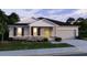 Charming single-story home at dusk with a stone facade, well-manicured lawn, and a two-car garage at 2349 Broadpoint Dr, Punta Gorda, FL 33983