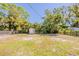 A large backyard features a storage shed, surrounded by lush trees, and a chain link fence at 2500 Erie S St, St Petersburg, FL 33712