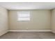 This cozy bedroom has neutral carpet, a painted brick accent wall, and a window with white blinds letting in natural light at 2500 Erie S St, St Petersburg, FL 33712