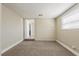 Carpeted bedroom with painted brick, a window, closet, and an open door offers a look into this home at 2500 Erie S St, St Petersburg, FL 33712