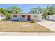 Inviting single-story home featuring a bright red door and a neatly manicured lawn at 2500 Erie S St, St Petersburg, FL 33712