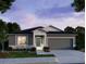 Charming single-story home with a two-car garage, enhanced by evening lighting at 25575 Calusa Dr, Punta Gorda, FL 33955