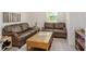Living room featuring two leather sofas, a center table, and neutral decor at 25575 Calusa Dr, Punta Gorda, FL 33955