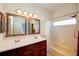 Well-lit bathroom with double vanity, framed mirrors, and a shower-tub combo at 27452 Amelia Isle Ct, Wesley Chapel, FL 33544