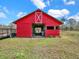 Red barn featuring a classic design, open entrance, and ample space, set on a lush green property with a pond at 8123 Double Branch Rd # 1, Tampa, FL 33635