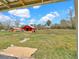 Exterior view of a red barn in a grassy yard, set against a blue sky with fluffy white clouds at 8123 Double Branch Rd # 1, Tampa, FL 33635