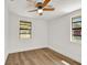 Bright bedroom featuring hardwood floors, white walls, and natural light through the windows at 8123 Double Branch Rd # 1, Tampa, FL 33635