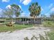 Inviting exterior view highlighting a home's screened-in porch, complemented by mature palm trees and lush lawn at 8123 Double Branch Rd # 1, Tampa, FL 33635