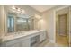 Bathroom with double sinks, vanity, and large mirror. Features a walk-in shower and a closet at 4914 Carova Way, Lakewood Ranch, FL 34211