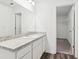 Modern bathroom vanity with a granite countertop and a view of a walk-in closet at 6156 Pina Colada St, Zephyrhills, FL 33542