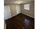 A bedroom showcasing dark wood floors and a double door closet at 6405 Gainsboro Dr, Port Richey, FL 34668