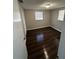 A bedroom showcasing dark wood floors and natural light from two windows at 6405 Gainsboro Dr, Port Richey, FL 34668
