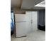 Spacious kitchen featuring white cabinets, marble flooring, and a new refrigerator at 6405 Gainsboro Dr, Port Richey, FL 34668