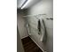 A laundry room with white walls, dark wood floor, and metal shelving at 6405 Gainsboro Dr, Port Richey, FL 34668