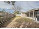 Spacious backyard featuring a partial fence and access to a screened-in porch, offering privacy and outdoor living space at 9811 Rainbow Ln, Port Richey, FL 34668