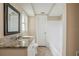 The bright bathroom is nicely appointed with granite counters and white cabinets at 9811 Rainbow Ln, Port Richey, FL 34668