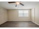 Bedroom features wood flooring, ceiling fan, and a window allowing natural light at 9811 Rainbow Ln, Port Richey, FL 34668