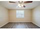 Bedroom featuring light colored walls, new wood flooring, and a bright window at 9811 Rainbow Ln, Port Richey, FL 34668