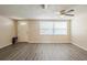 Spacious living room featuring light colored walls, new wood flooring, and a bright window at 9811 Rainbow Ln, Port Richey, FL 34668