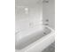 Bright bathroom features a clean white tiled tub and shower combination at 12066 Cavern Rd, Spring Hill, FL 34609