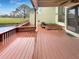 Backyard with a wooden deck overlooking a pond and the golf course at 13516 Palmwood Ln, Tampa, FL 33618