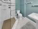Modern bathroom with glass-enclosed shower, white tile and fixtures, and ceramic-tiled floors at 13516 Palmwood Ln, Tampa, FL 33618