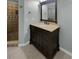Stylish bathroom featuring dark wood vanity, shower with brown tile, and modern fixtures at 13516 Palmwood Ln, Tampa, FL 33618
