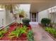 Beautiful front entrance featuring vibrant landscaping and covered entry at 13516 Palmwood Ln, Tampa, FL 33618