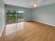 Bright living room features hardwood floors and a sliding glass door to balcony with a scenic view at 13516 Palmwood Ln, Tampa, FL 33618