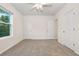Spacious carpeted bedroom with a ceiling fan, two closets, and a bright window view at 32859 Pez Landing Ln, Wesley Chapel, FL 33543