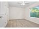 Well-lit carpeted bedroom with a ceiling fan and a view of the trees through the window at 32859 Pez Landing Ln, Wesley Chapel, FL 33543