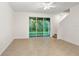 Bright living room with tile flooring, staircase, and sliding glass doors to the backyard at 32859 Pez Landing Ln, Wesley Chapel, FL 33543