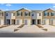 Exterior view of a modern townhome with a gray and white facade and a one-car garage at 32859 Pez Landing Ln, Wesley Chapel, FL 33543