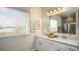 Bathroom featuring a dual sink vanity with white countertops and cabinets, framed art, and a large mirror at 25138 Calusa Dr, Punta Gorda, FL 33955