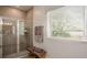 Bathroom showcasing tiled shower with glass door, complementary brown towels, and a bright window at 25138 Calusa Dr, Punta Gorda, FL 33955
