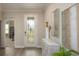 Inviting foyer featuring a decorative front door, modern console table, and stylish artwork at 25138 Calusa Dr, Punta Gorda, FL 33955