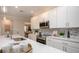 Bright kitchen featuring white cabinets, stainless steel appliances, large island with countertop dining, and pendant lighting at 25138 Calusa Dr, Punta Gorda, FL 33955