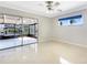 Bright bedroom with tile flooring, ceiling fan, and sliding glass doors to the lanai with waterfront views at 513 Flamingo Dr, Apollo Beach, FL 33572