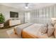 Bright bedroom with a large bed, ceiling fan, and a TV above a wooden dresser at 513 Flamingo Dr, Apollo Beach, FL 33572