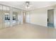 Spacious bedroom features mirrored closet doors, a ceiling fan, and neutral decor, with access to an ensuite bath at 513 Flamingo Dr, Apollo Beach, FL 33572